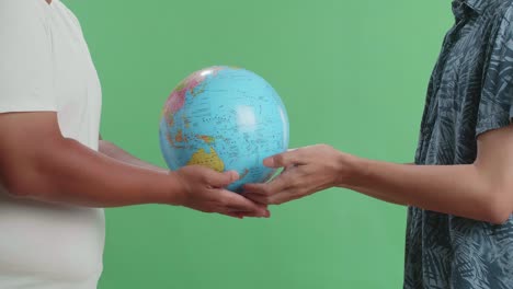 two people holding a globe