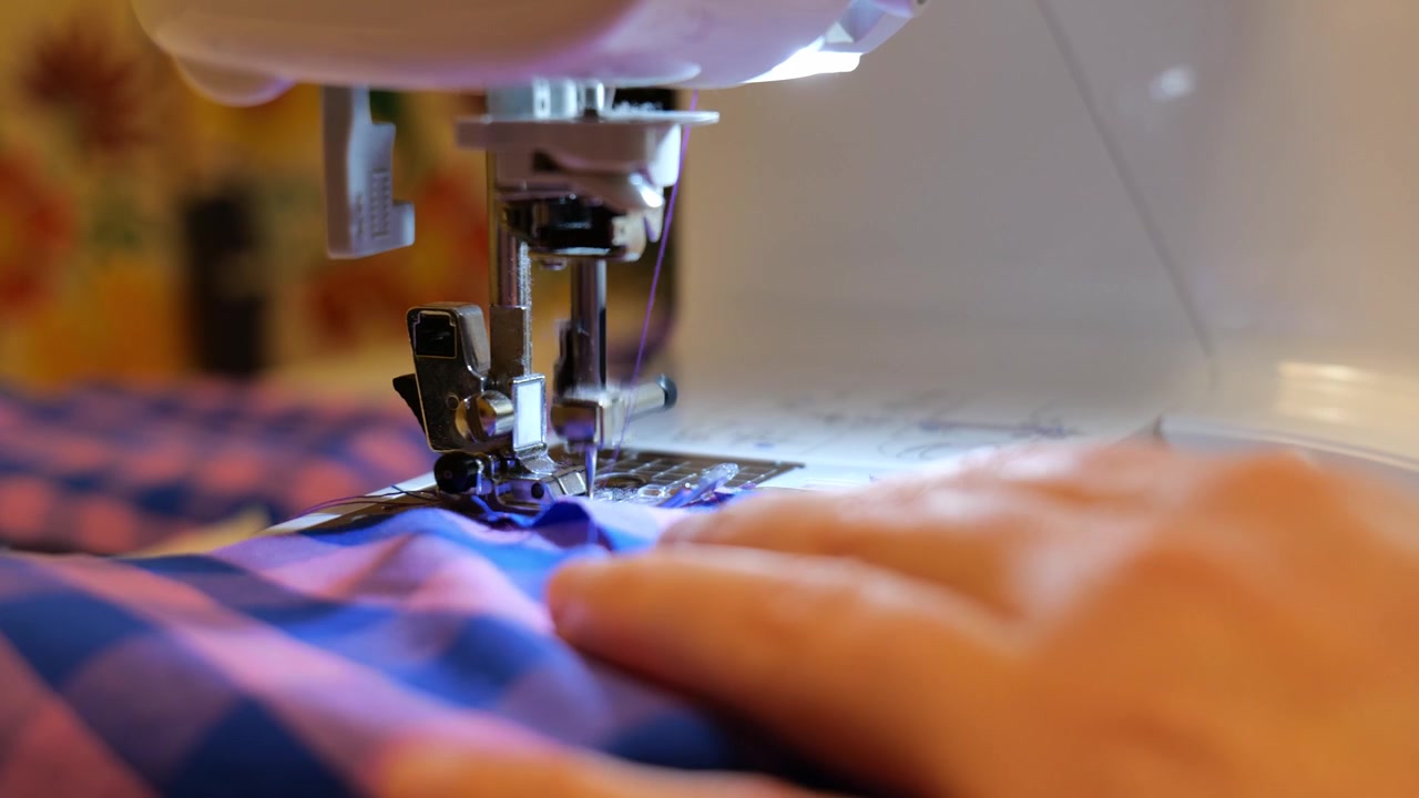 Close Up Tailor Hands Crafting Fabric Garment on Electric Sewing Machine