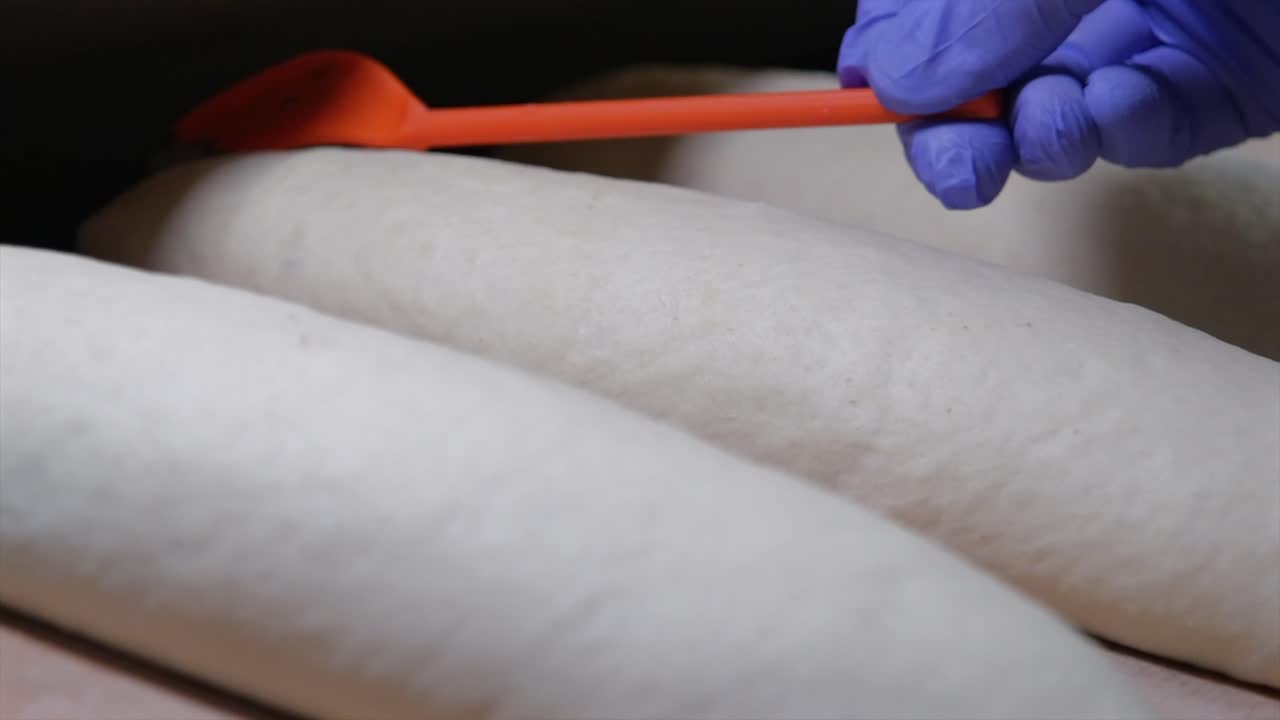 el panadero rasca la masa del pan