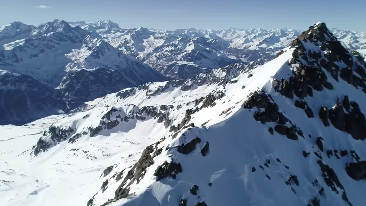 Explore the stunning beauty of snow-covered peaks rising against a clear blue sky in the Swiss Alps. This aerial view showcases the grandeur of nature in winter.