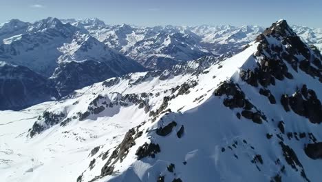 explore the stunning beauty of snow-covered peaks rising against a clear blue sky in the swiss alps. this aerial view showcases the grandeur of nature in winter.