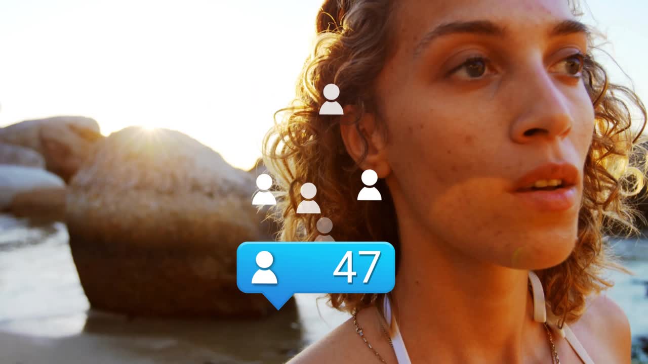 woman on sunset beach seeing notification bubble fading in floating icons marking marketing metrics
