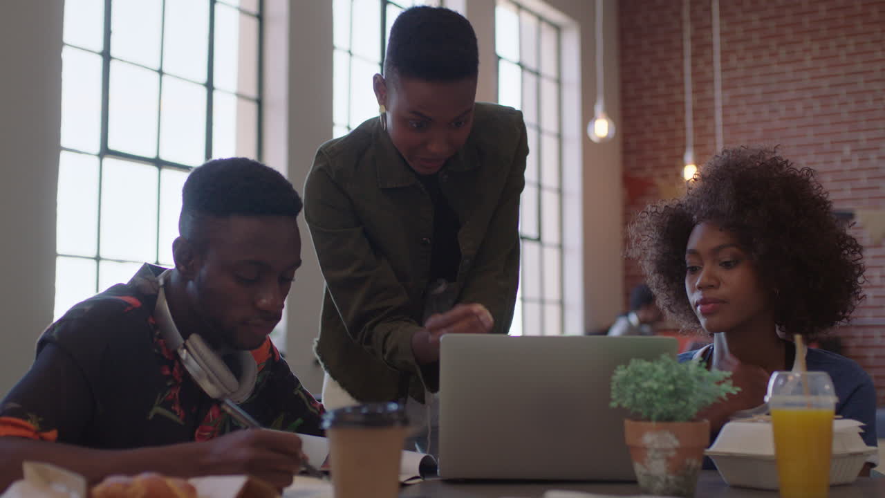 gente de negocios negra creativa reunión líder de equipo mujer entrenando colegas compartiendo ideas en computadoras portátiles lluvia de ideas en el lugar de trabajo de la oficina moderna