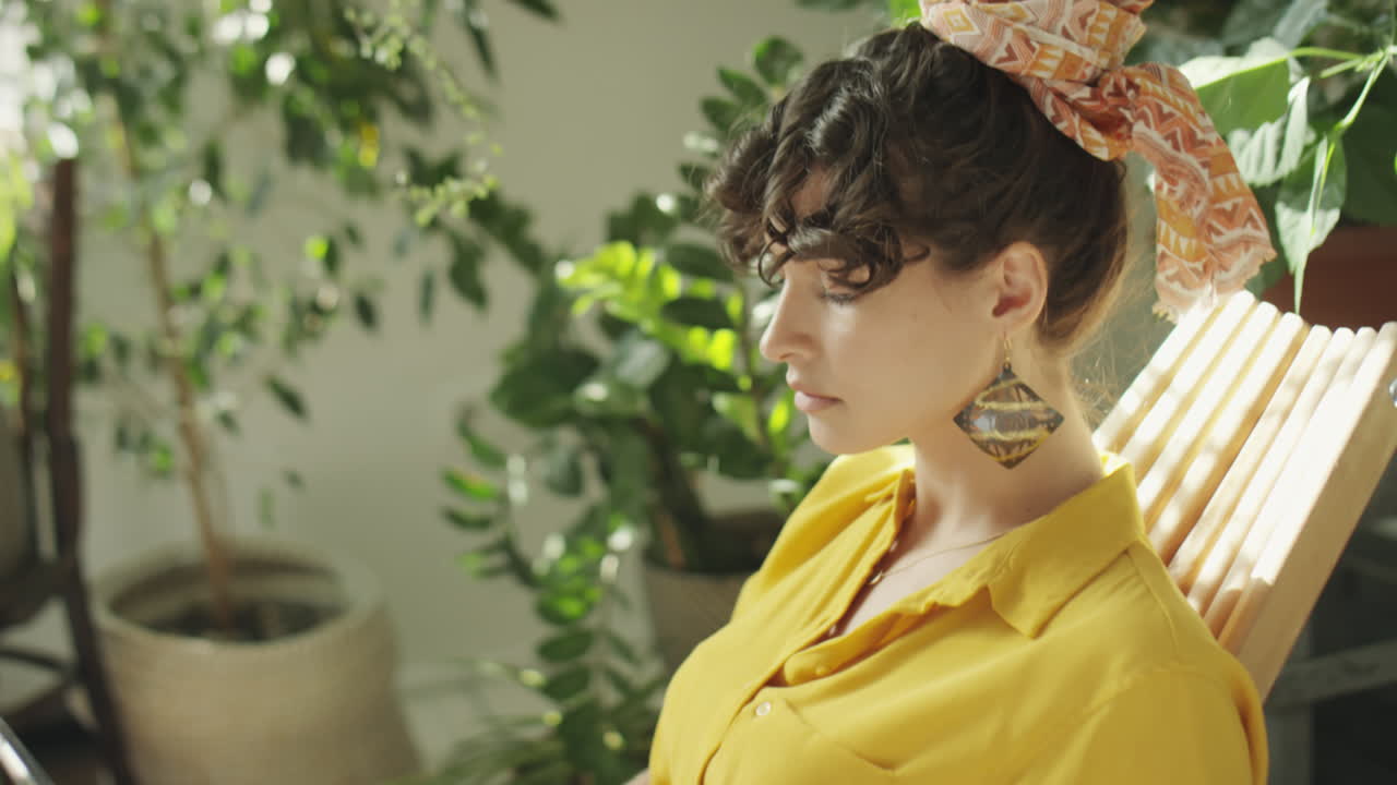 Woman Working on Laptop among Houseplants