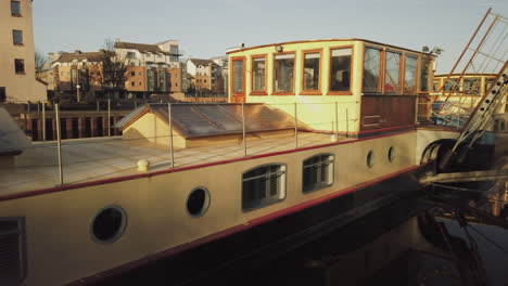 pan across yellow vintage barges moored at the exit to albert dock basin on a sunny day, edinburgh, lothian, uk