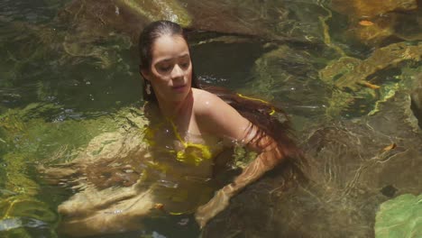 a girl in bikini find happiness at a tropical waterfall and river in the caribbean.