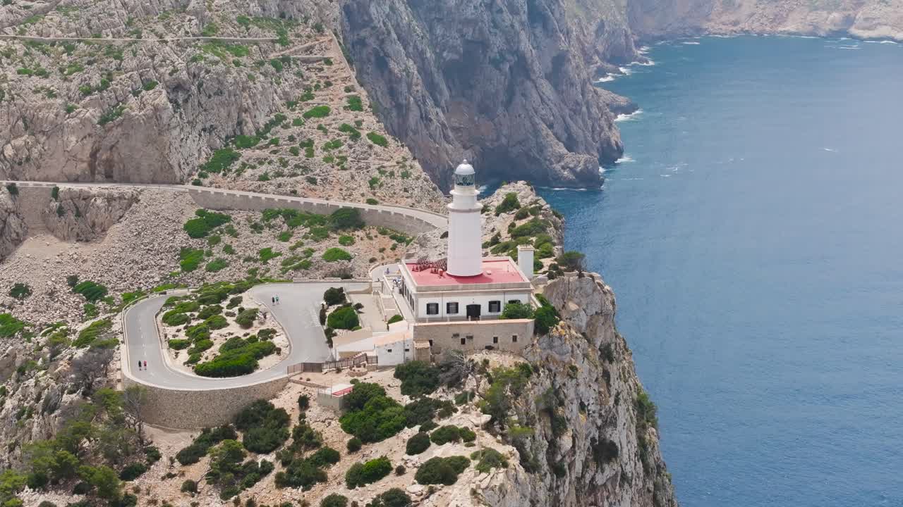 Scenic drone view of Formentor Lighthouse tower near steep cliff edge, Spain