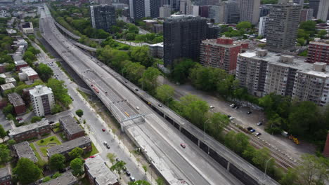 aerial view of fluid cars traffic on suburban highway in montreal area canada, modern multi-lanes driveway road infrastructure surrounded by residential buildings towers and homes