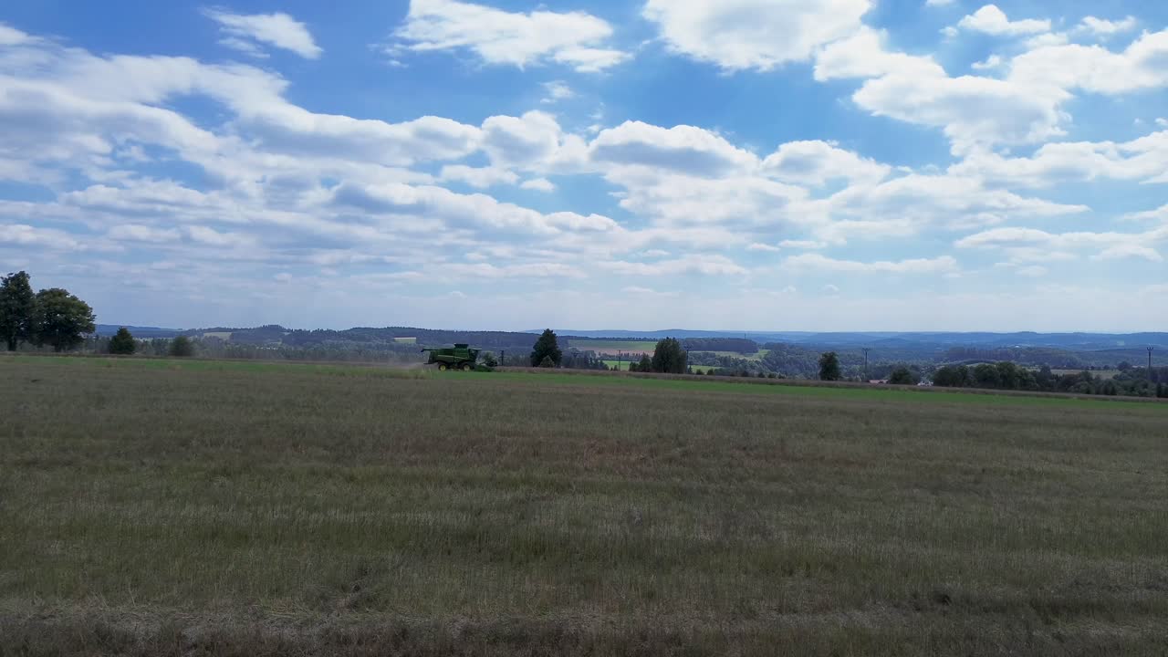 una vista de la cosecha combinada eficiente en acción cuando la cámara del dron captura el lado de la cosecha combinada en movimiento