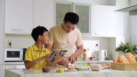 hombre asiático y niño en la cocina