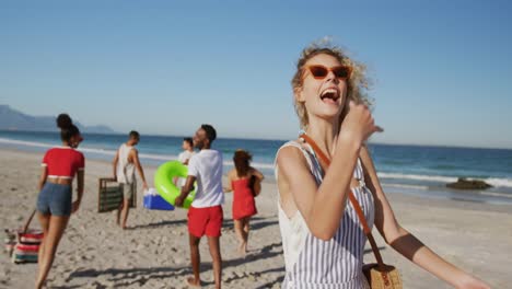 jóvenes amigos adultos de vacaciones caminando por una playa 4k