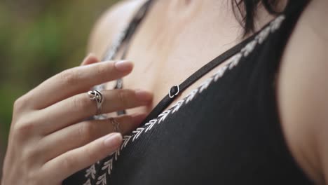 mujer joven sudando en un día caluroso, tocando suavemente su cuello y pecho con los dedos, moviéndose lentamente hacia abajo de cerca