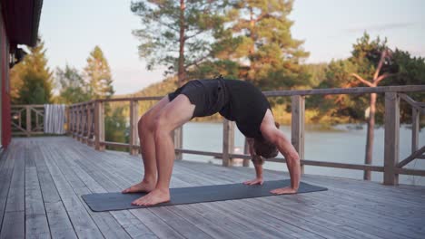 wheel yoga pose - man doing backbends on the yoga mat