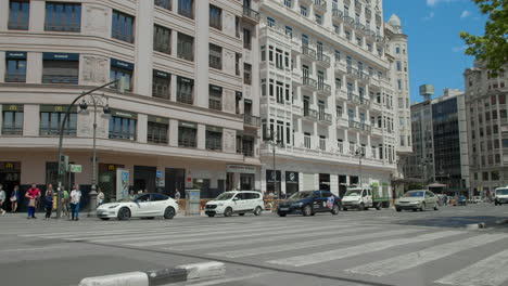 a crowd of people crossing a busy city street