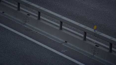 coches conduciendo por la noche en la autopista de la gran ciudad disparado por un dron. autopista moderna barrera de choque.