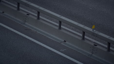 cars driving evening highway big city drone shot. freeway modern crash barrier.