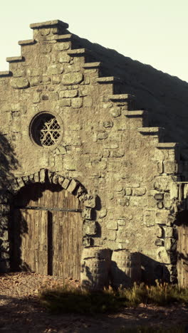 stone building with wooden door and barrels