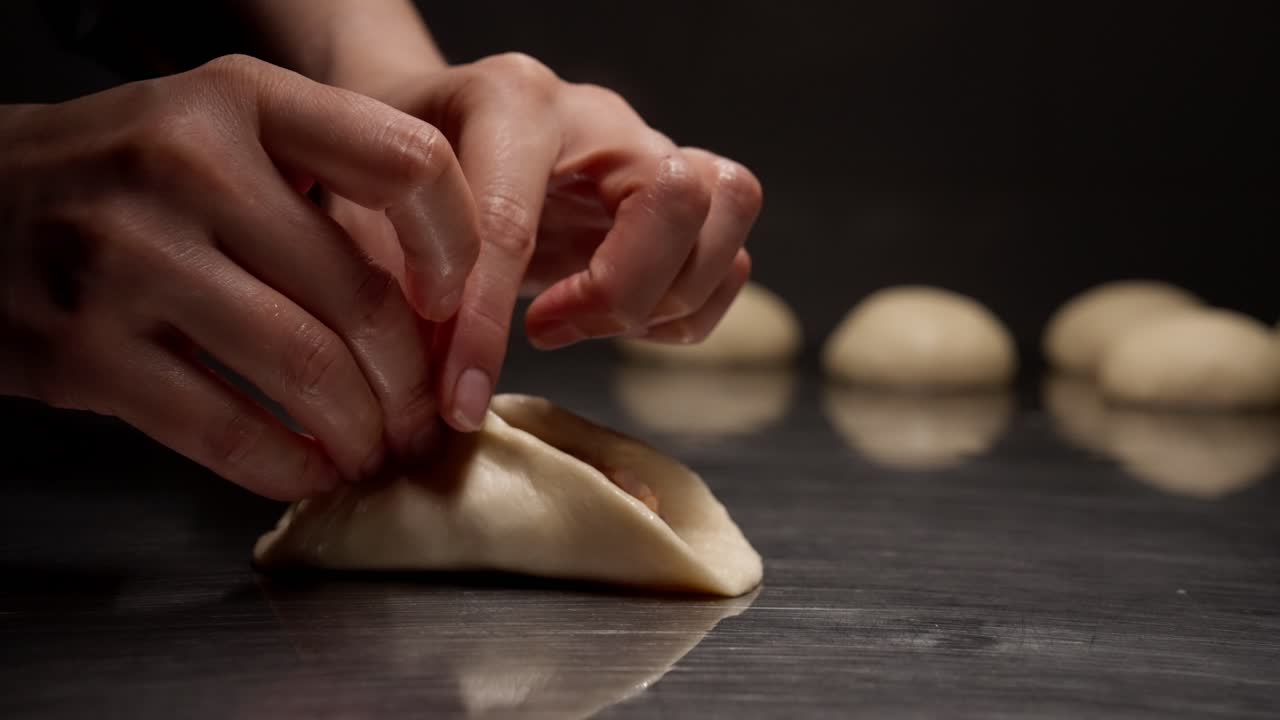 Hands Folding Dough with Filling for Dumplings