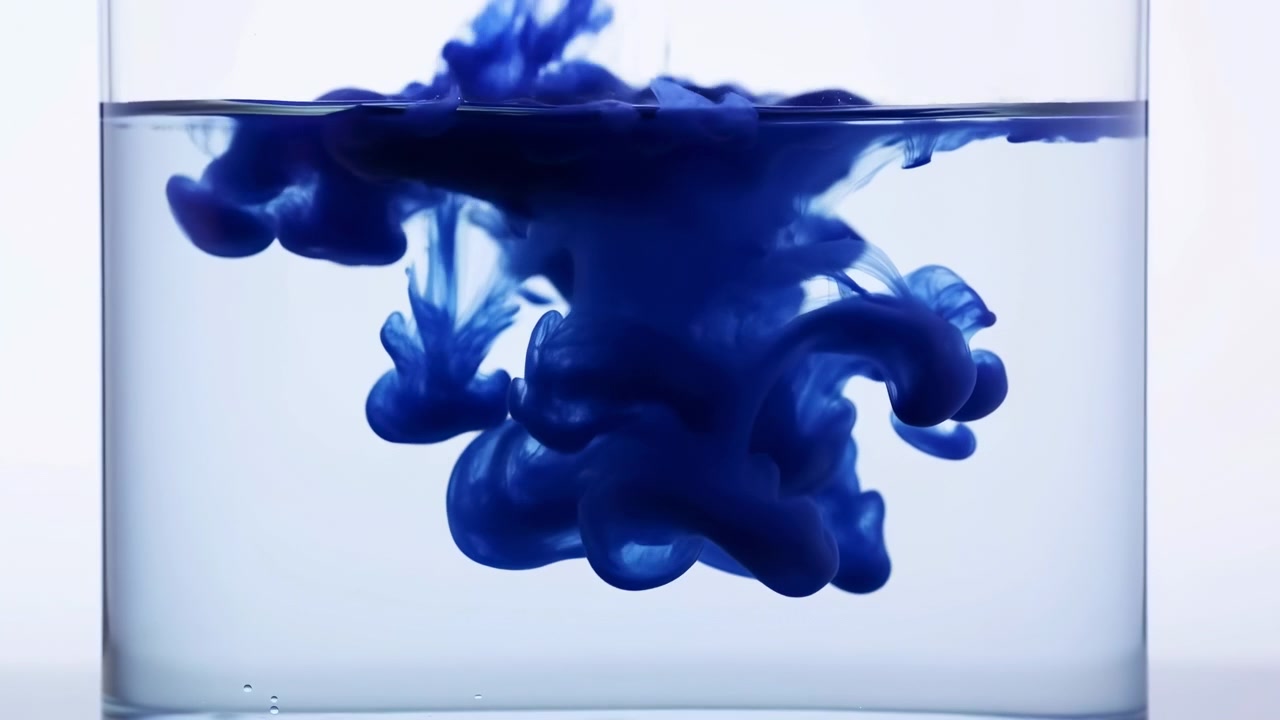 Dense cobalt-blue ink disperses beneath straight waterline inside clear rectangular glass, creating bulbous clouds, curling tendrils, fine filaments, soft contrast, and abstract studio motion