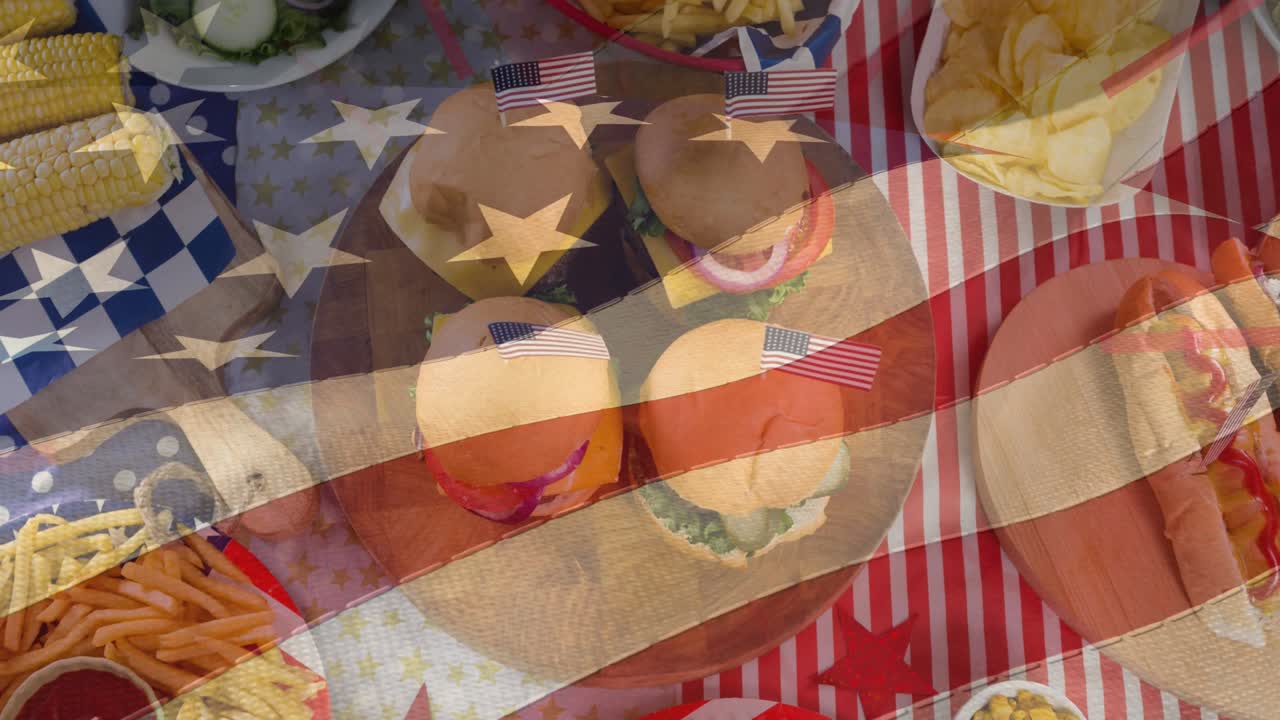 미국 국기의 애니메이션이 축제 간식, 핫도그 및 햄버거 위로 움직입니다.