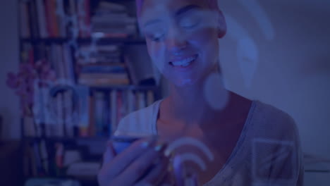 animación de múltiples iconos digitales sobre mujer caucásica usando teléfono inteligente en casa.