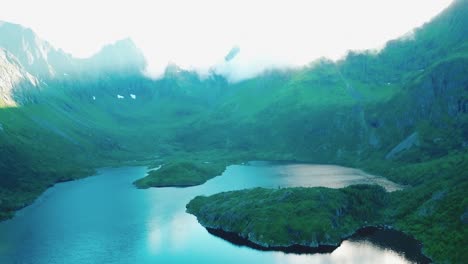 Tilt-up-reveal-drone-shot-of-surrounding-rocky-hills-over-lake-Agvatnet-in-Lofoten