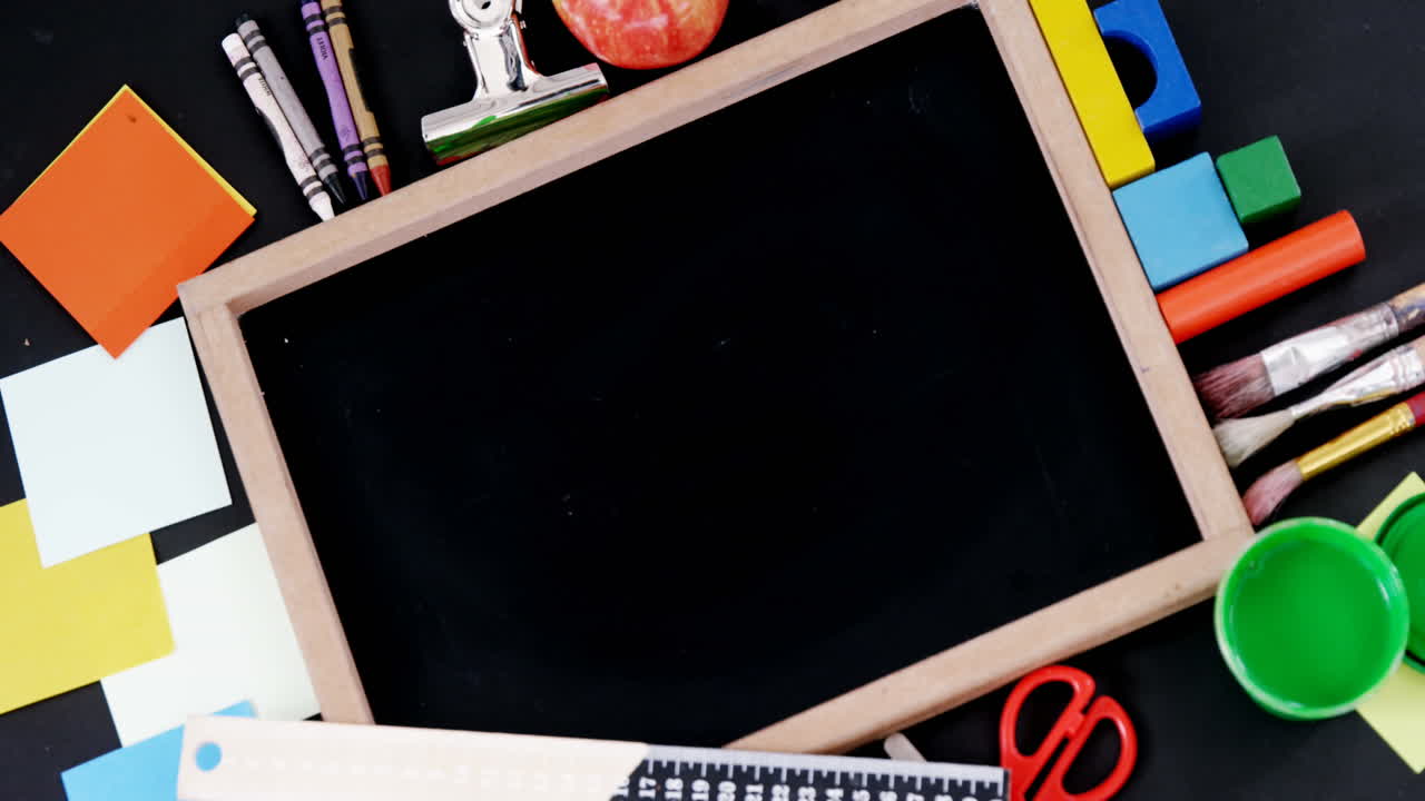 icono de edificio escolar contra pizarra de madera y equipos escolares en una mesa