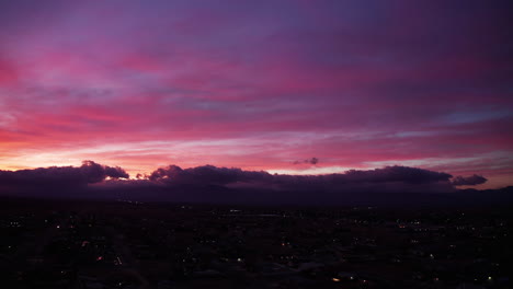 panoramic aerial view with the city below and a stunning sunset beyond the horizon