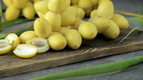 las palmeras de dátiles frescas se colocan en la mesa con aceite, concepto de alimentos saludables. palmeras de dátils. frutas crudas de palmieras de dátiles (phoenix dactylifera)