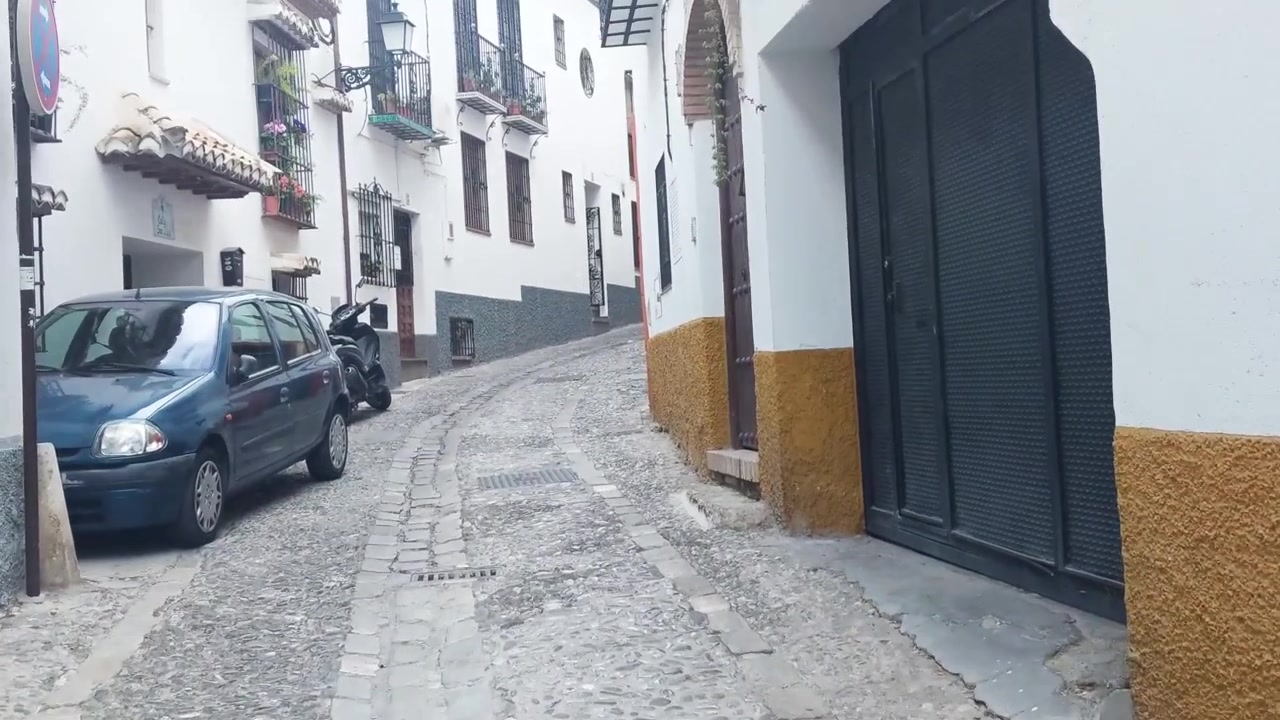 Cena em primeira pessoa de um menino andando em uma rua tradicional espanhola de paralelepípedos