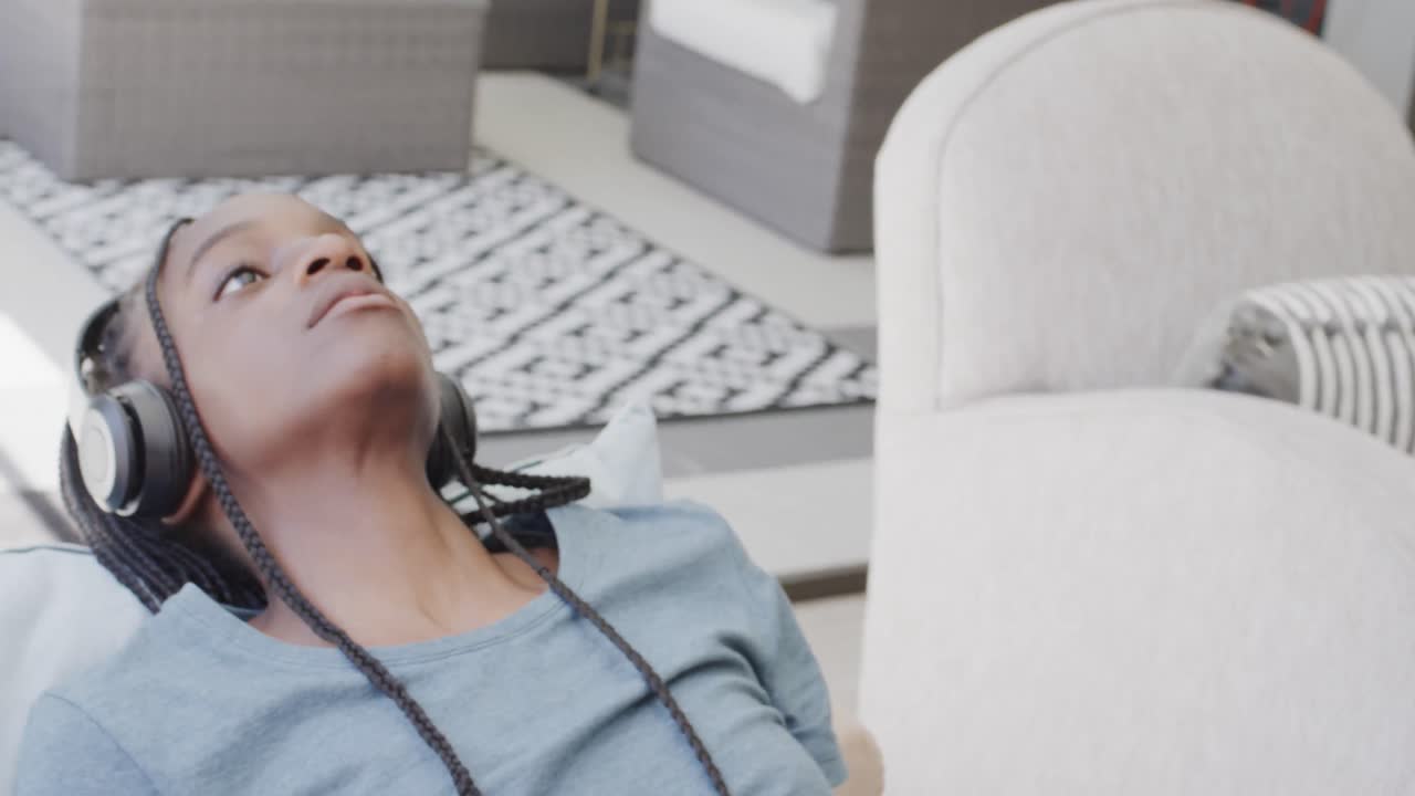 헤드폰을 쓰고 음악을 듣고 있는 사려 깊고 화가 난 아프리카계 미국인 십대 소녀