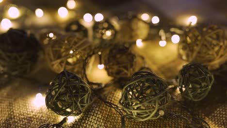 close-up christmas garland and handmade balls on a playd with golden lights. christmas concept. home decor