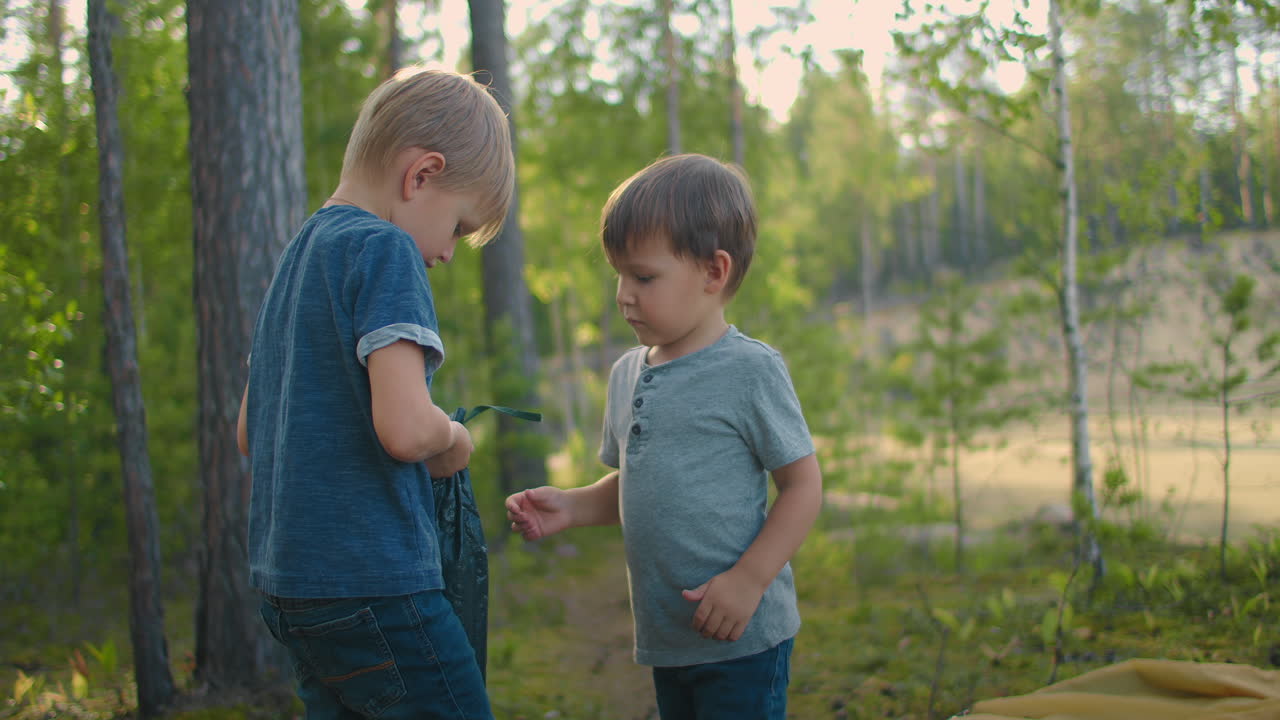 dos niños pequeños en el bosque ayuda a poner y establecer una tienda en cámara lenta