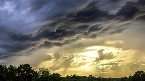 Timelapse-De-Nubes-Tormentosas-Con-Refracciones-De-Luz-Solar-Amarilla,-Nubes-En-Capas-Sobre-El-Bosque-Al-Amanecer,-Hermosa-Vista,-Formación-De-Nubes-En-Azul,-Naranja,-Cielo-Sombrío-Y-Brumoso-En-El-Horizonte,-Nubes-épicas