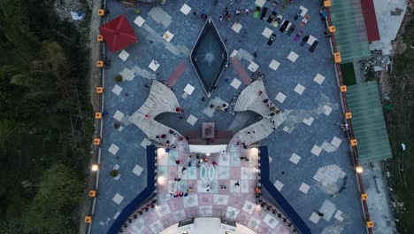 Top-down-rising-view-of-tourists-walking-around-lord-shiva-statue-in-pumdikot-nepal