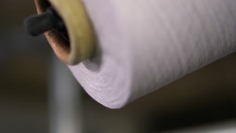 Close-up-shot-of-Spools-with-white-thread-at-rewinding-machine-video---Socks-production