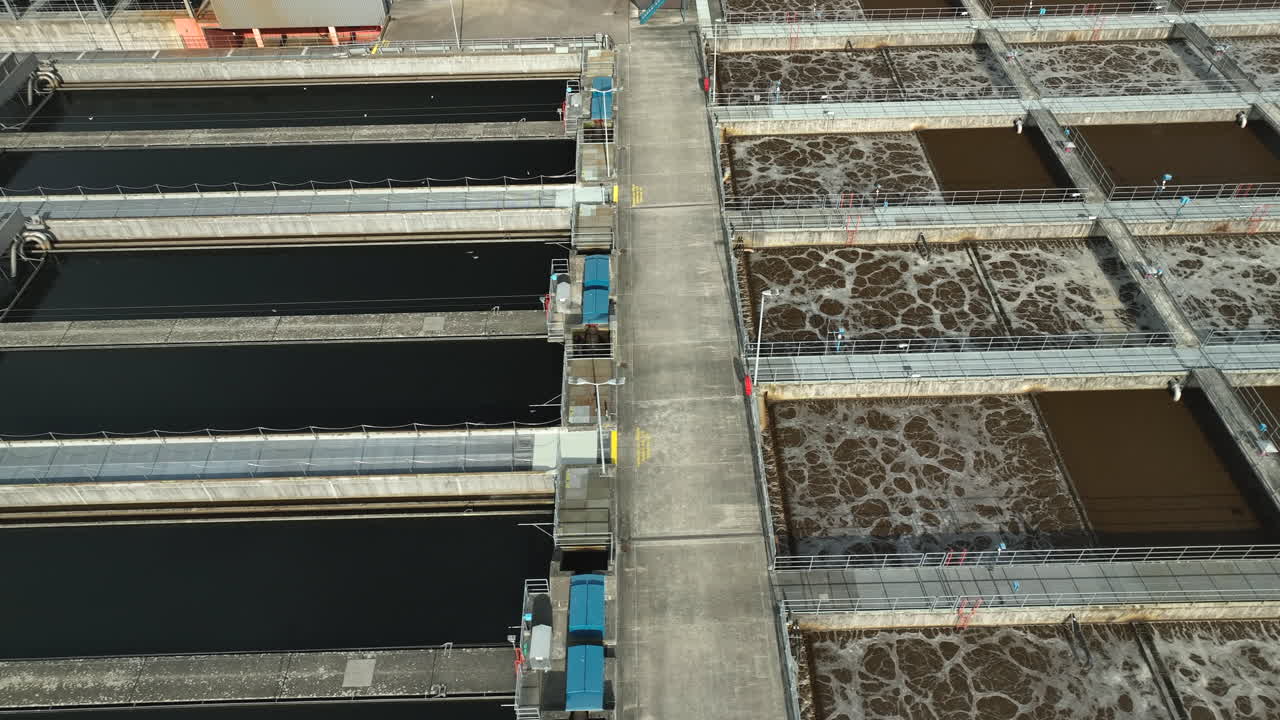 aguas residuales marrones flotando en piscinas de un tratamiento de agua junto a la instalación de agua limpia