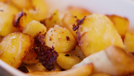 delicious roasted potatoes and parnsips root vegetables in serving bowl ready to eat at family dinner table at thanksgiving or christmas party food gathering 4k