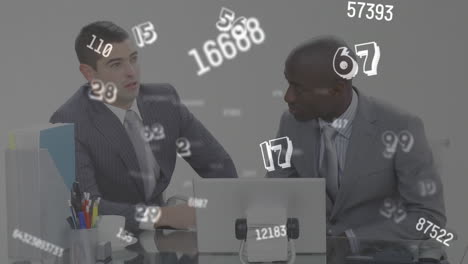 digital animation of multiple changing numbers and symbols against two businessman using laptop