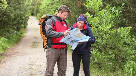 couple walking along a country trail looking at map