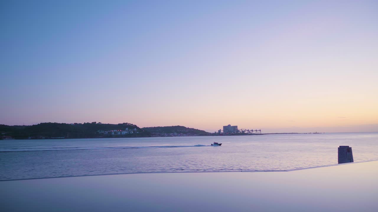 Lisbon Tagus river at sunset with sea skyline, sport boat passing and artificial lake reflection 4K