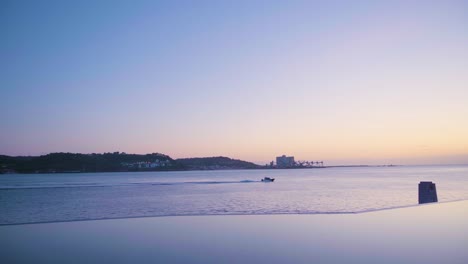 Lisbon Tagus river at sunset with sea skyline, sport boat passing and artificial lake reflection 4K
