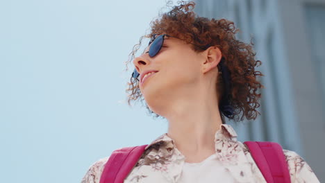 Tourist-man-in-sunglasses-looking-around-having-positive-good-mood-in-urban-summer-city-sunny-street