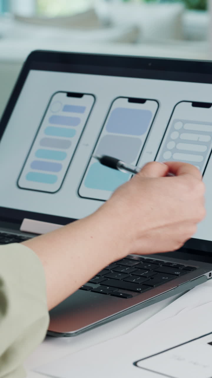 Hand Pointing at Mobile App UI Design on Laptop Screen