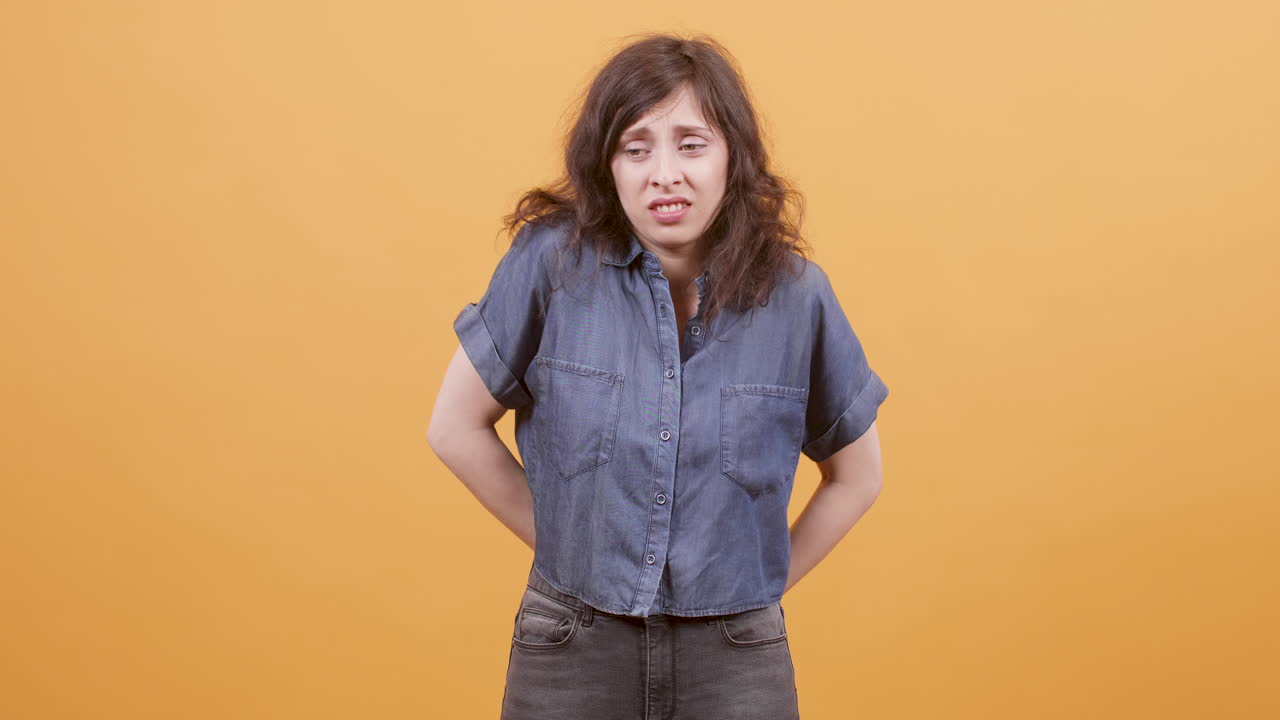 Distressed woman in denim shirt expressing negative emotions