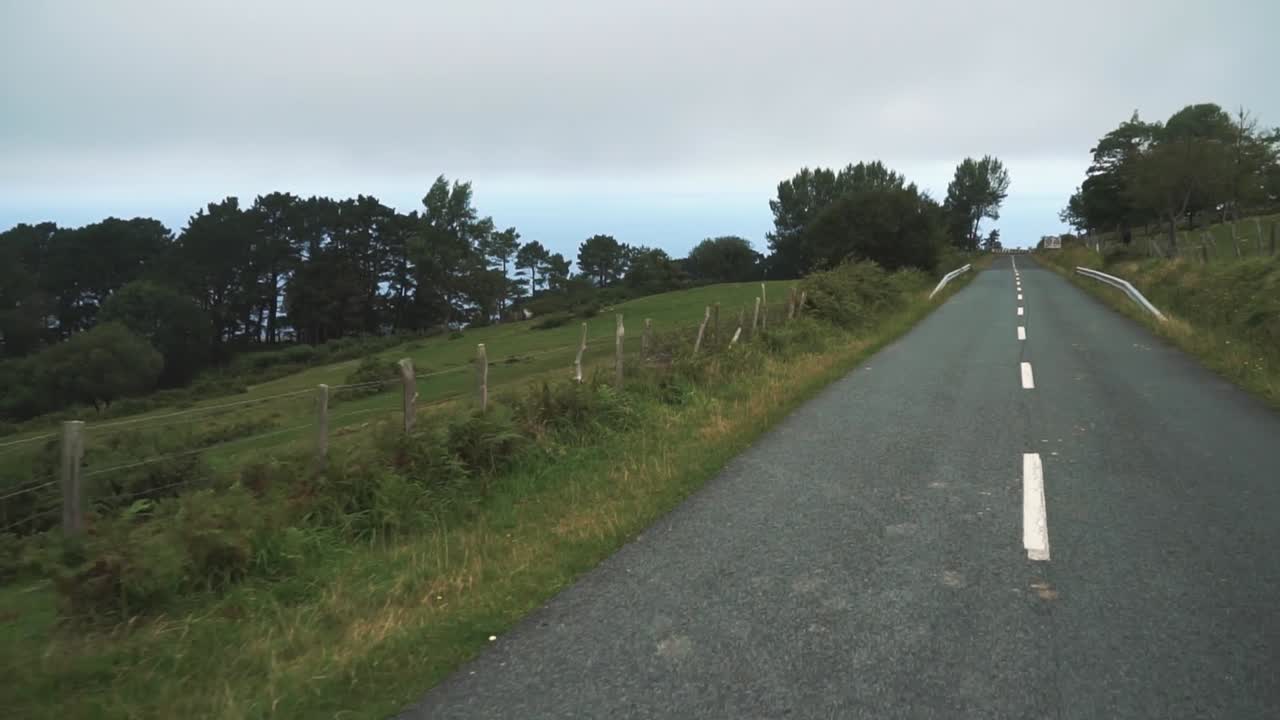 짐벌로 슬로우 모션으로 촬영된 작은 산길을 따라 자동차가 움직이고 있습니다.