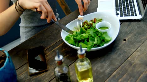 young woman having salad on the table 4k