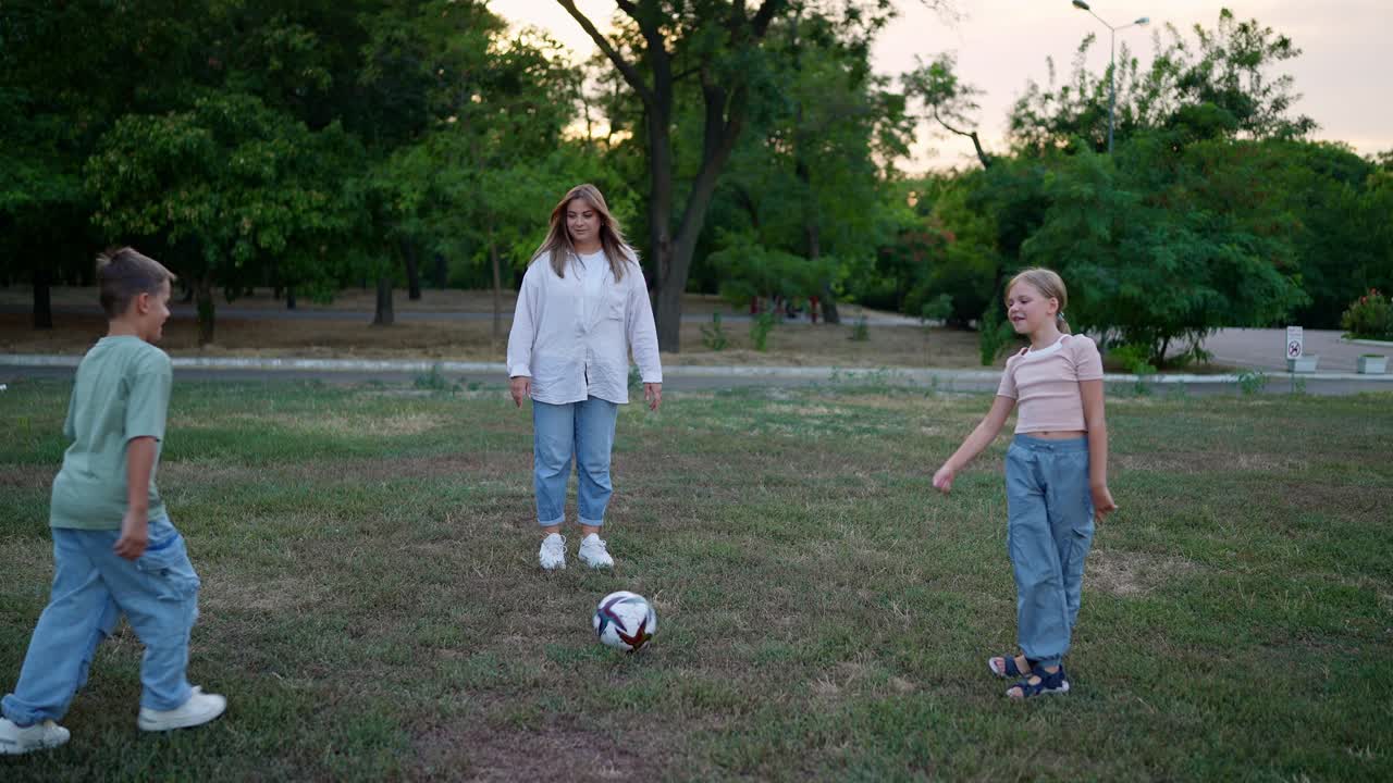 семья играет в футбол в парке