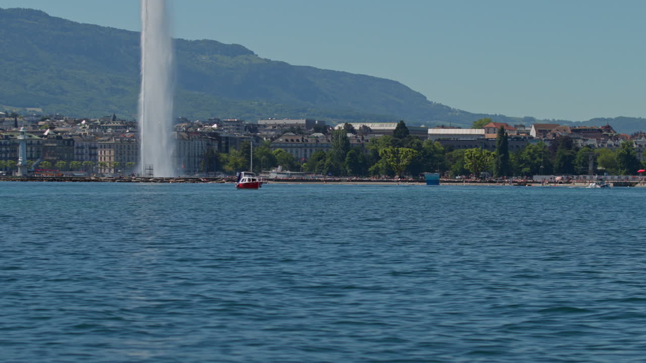 Peaceful morning in Geneva with the iconic Jet d’Eau rising from the lake, calm waters reflecting the clear sky, and the city slowly coming to life in the morning light.