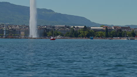 peaceful morning in geneva with the iconic jet d’eau rising from the lake, calm waters reflecting the clear sky, and the city slowly coming to life in the morning light.